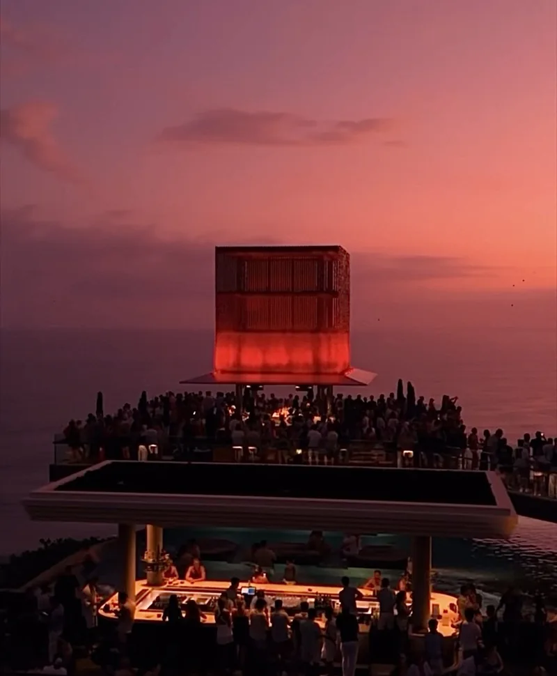 The lit cube at Savaya at dusk, the decks full