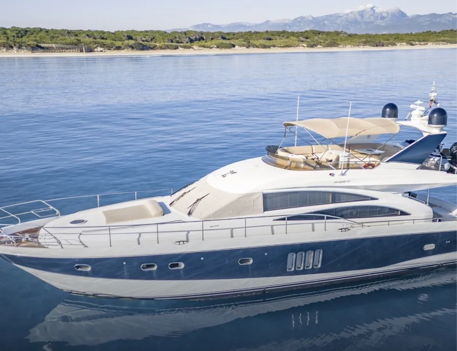 A motor yacht lying at anchor on flat water off Mallorca, the Tramuntana behind