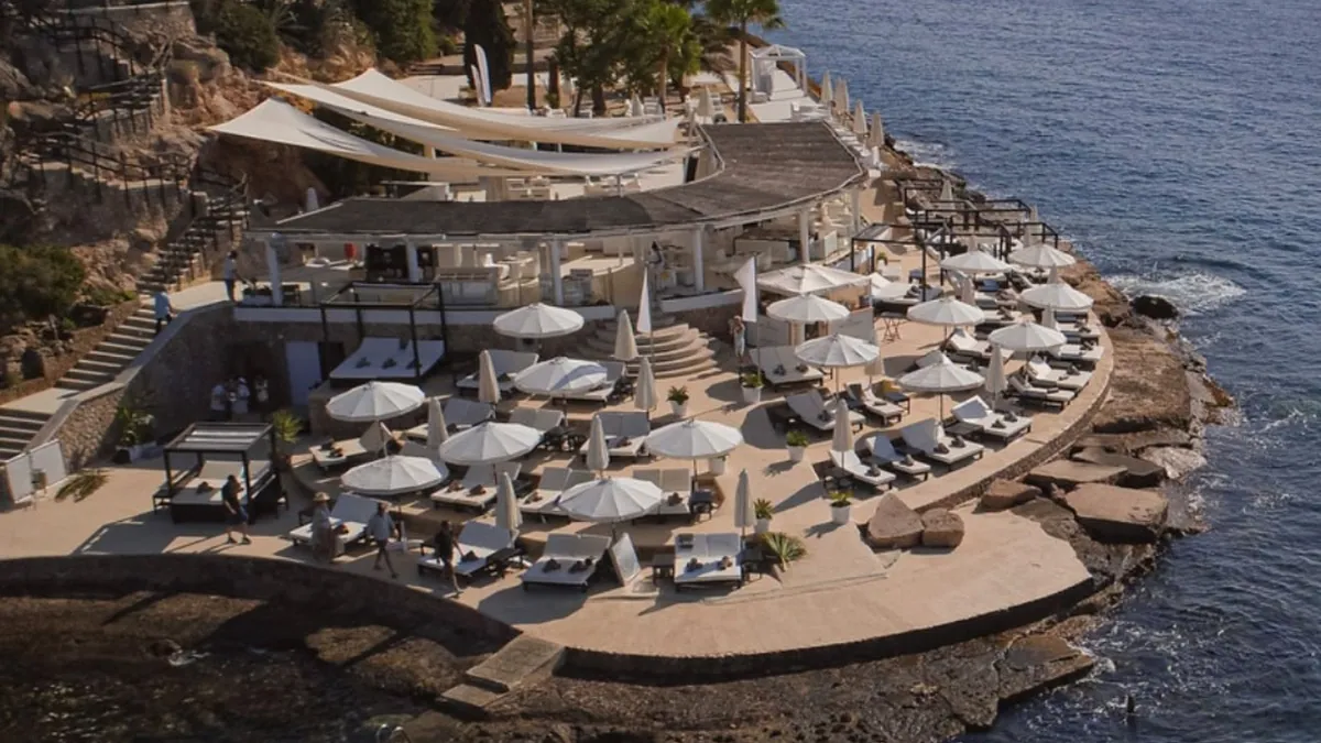 A beach club terrace on the rocks above clear water
