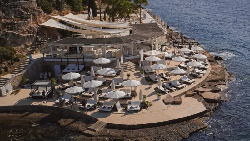 Sunbeds and white parasols on the rock terrace at Purobeach Palma
