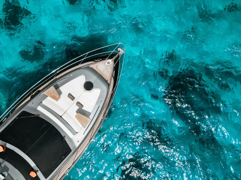The forward sun pad on Hype, from above, over clear water