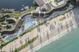 RAVA Beach Club at Laguna from the air, its pool curving along the beachfront